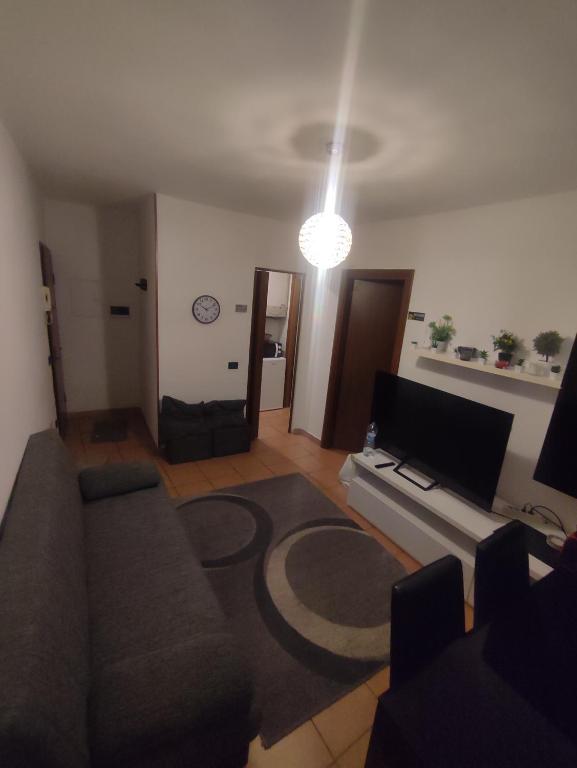 a living room with a couch and a tv at Casa a 5 minuti dal centro di Tortona in Tortona