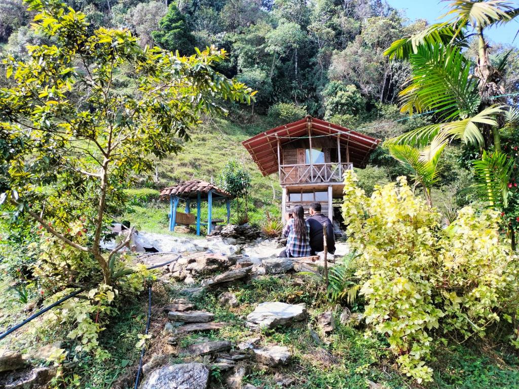 dos personas parados frente a una casa pequeña en Sierra de viboral adventures, en Medellín