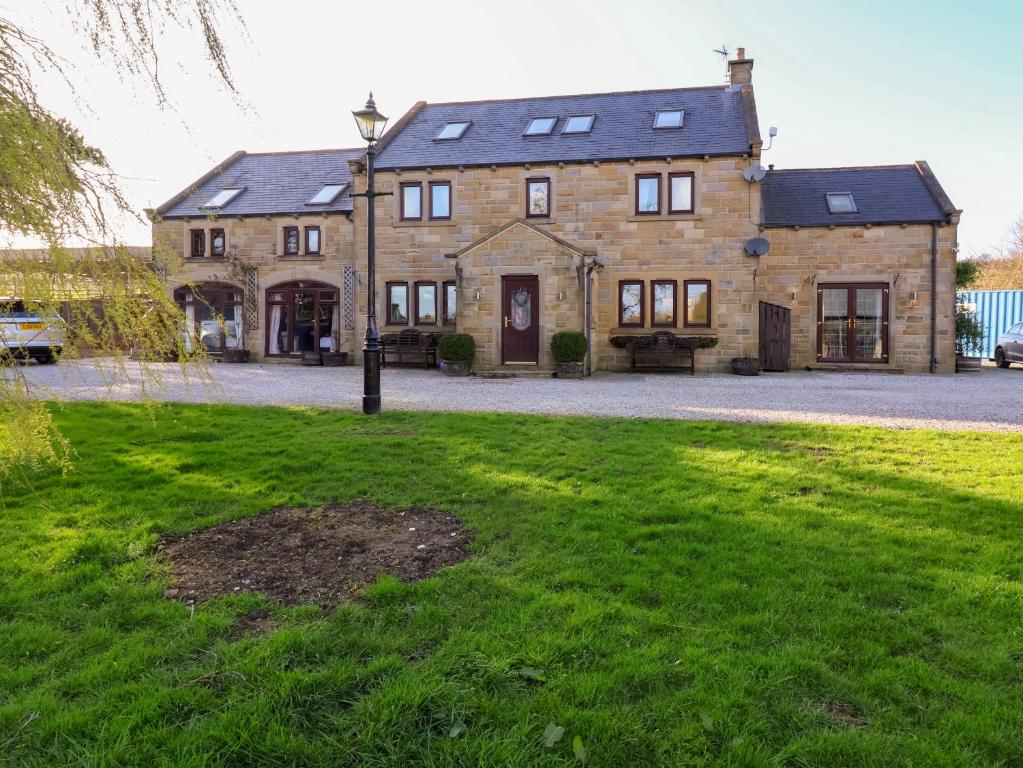 a large brick house with a green lawn in front of it at Farm View Hall in Harrogate