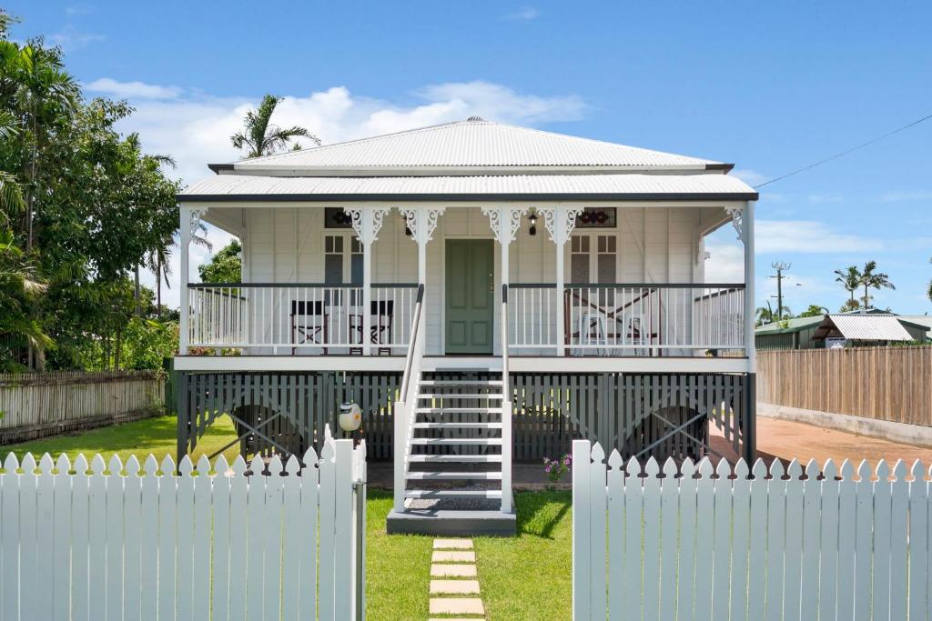 a white picket fence in front of a house with a gate at Charming 3-Bedroom Retreat in Townsville