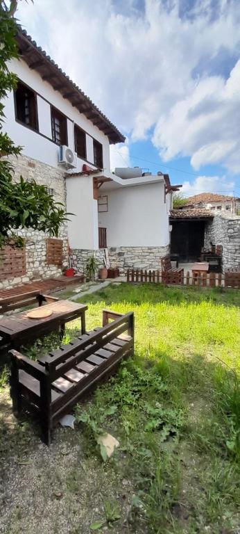 een tuin met een houten bank voor een huis bij Villa Maria - Berat Castle in Berat