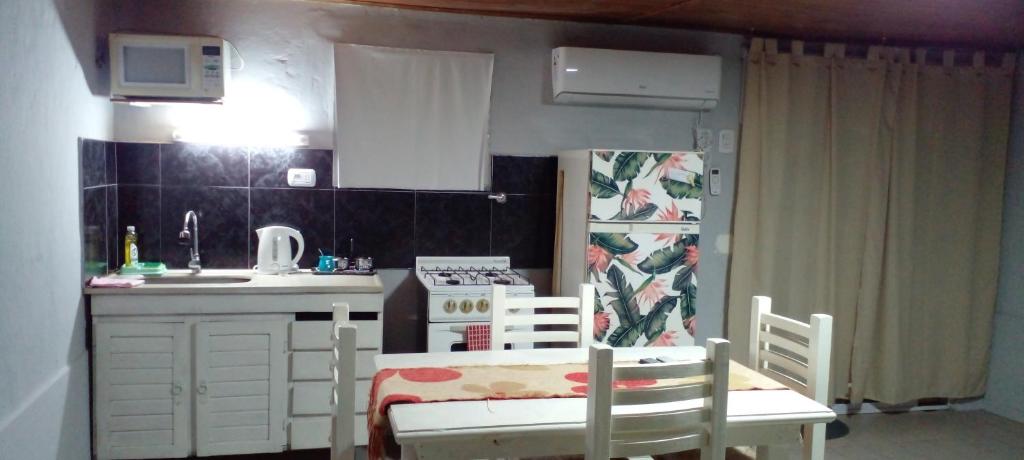 a small kitchen with a table and chairs in a room at Departamentos Avellaneda in Carhué