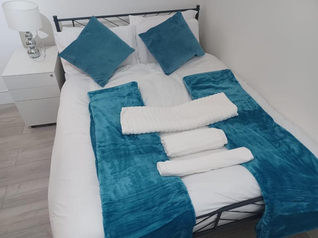 a bed with blue and white sheets and pillows at Sandra Stay MP in London