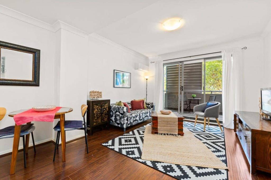 ein Wohnzimmer mit einem Sofa und einem Tisch in der Unterkunft Spacious 1-Bed with Pool & Gym 5 Minutes from CBD in Sydney