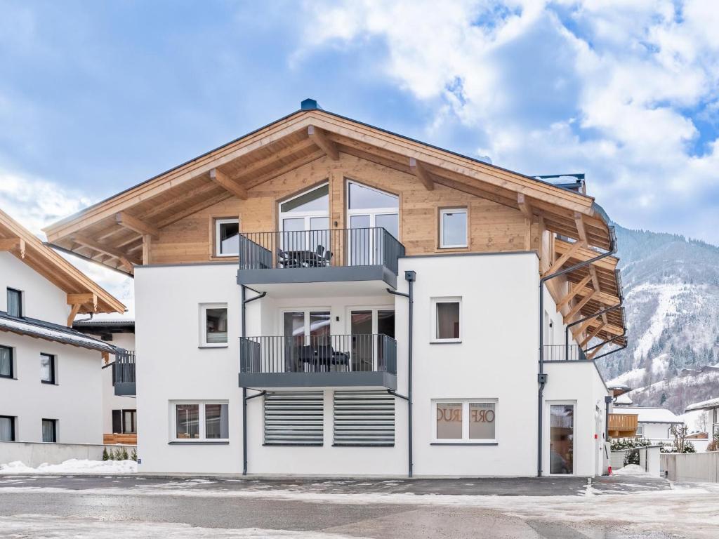 a large white building with a wooden roof at Falken Suites TOP 8 in Kaprun