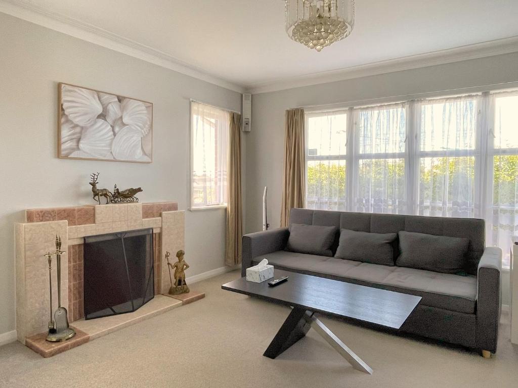 a living room with a couch and a fireplace at Home in central Auckland in Auckland