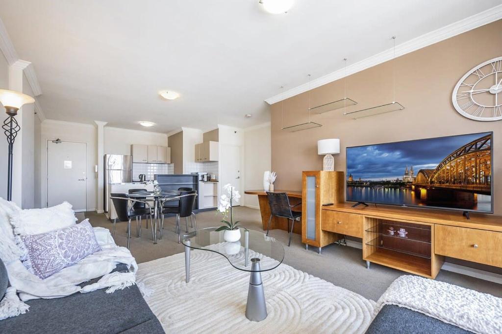 sala de estar con TV grande en la pared en Convenient 2-Bed Apartment in the Heart of Perth en Perth