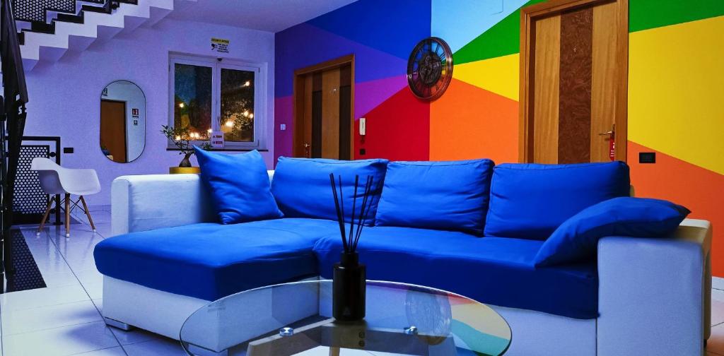- un salon avec un canapé bleu et un mur coloré dans l'établissement Utopia Bed & Breakfast, à Marigliano
