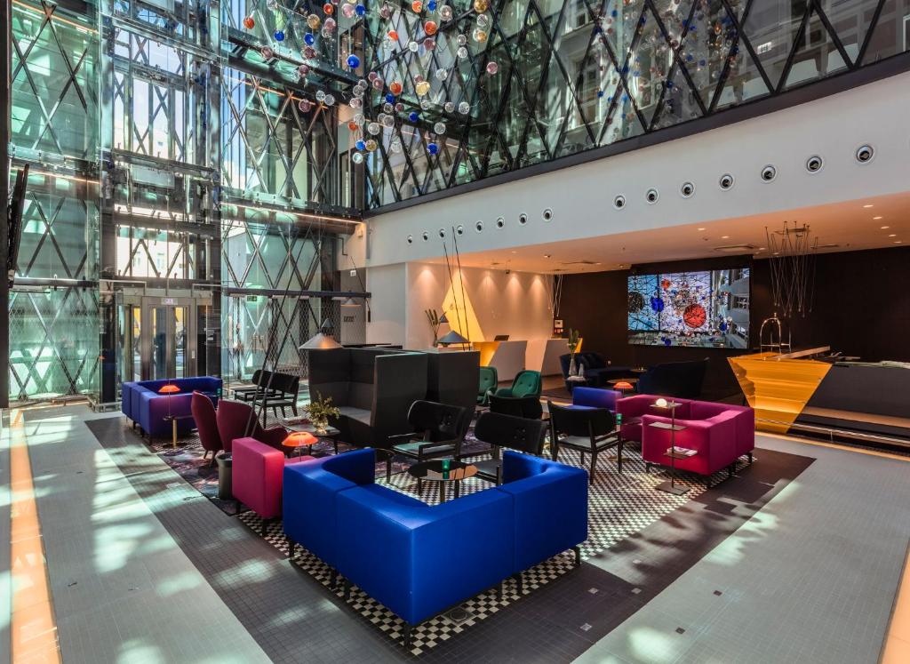 eine Lobby mit farbenfrohen Möbeln und einem großen Fenster in der Unterkunft Hotel Indigo Warsaw Nowy Świat, an IHG Hotel in Warschau