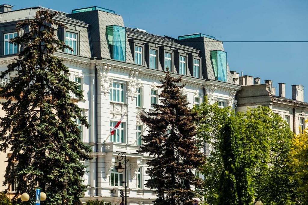 a building with two christmas trees in front of it at Hotel Indigo Warsaw Nowy Świat, an IHG Hotel in Warsaw