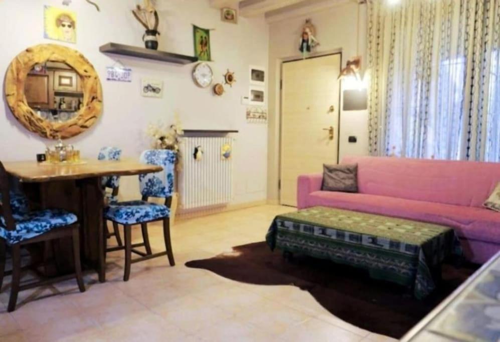 - un salon avec un canapé rose et une table dans l'établissement La casa dell'ulivo, à Brembate