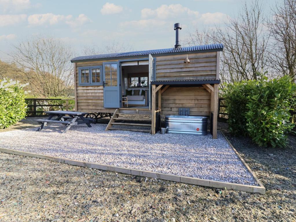 a tiny house with a picnic table and a bench at Shepherd Hut 2 in Harrogate
