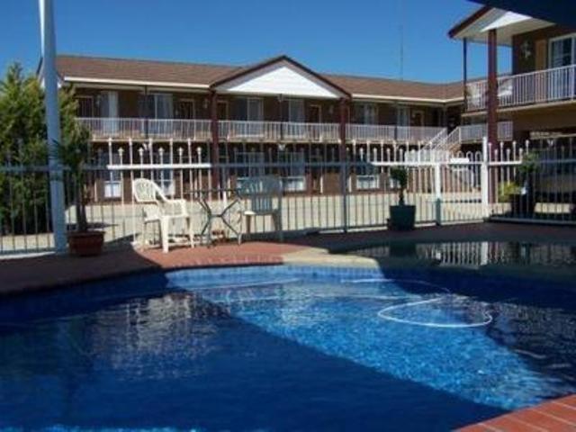 una gran piscina azul frente a un edificio en Albury Classic Motor Inn en Albury