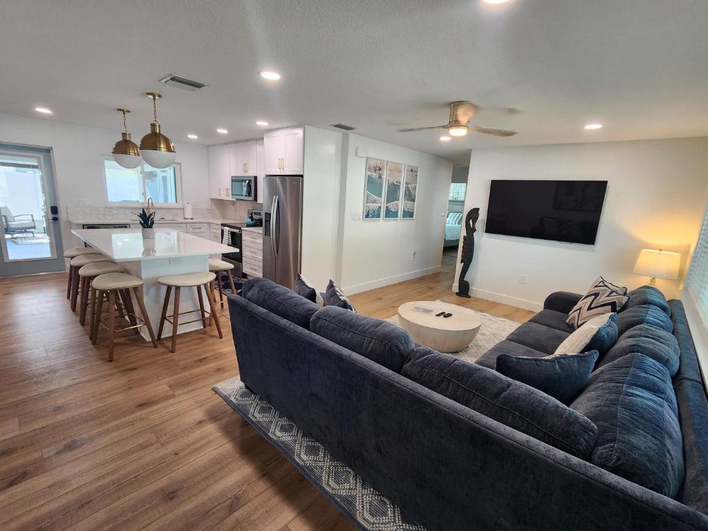 uma sala de estar com um sofá grande e uma cozinha em Drift House - 4Bed 3Bath Private Pool House em Cape Canaveral