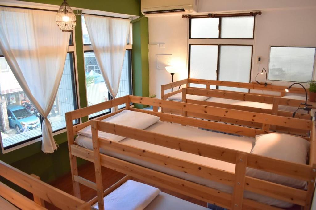 a room with two bunk beds and windows at Lazy House in Hualien City