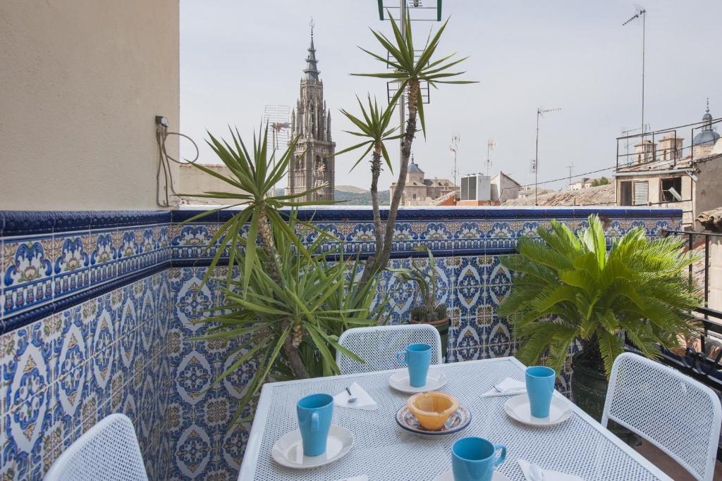 - Balcón con mesa y sillas y torre del reloj en Atico-Terraza Imperial, en Toledo