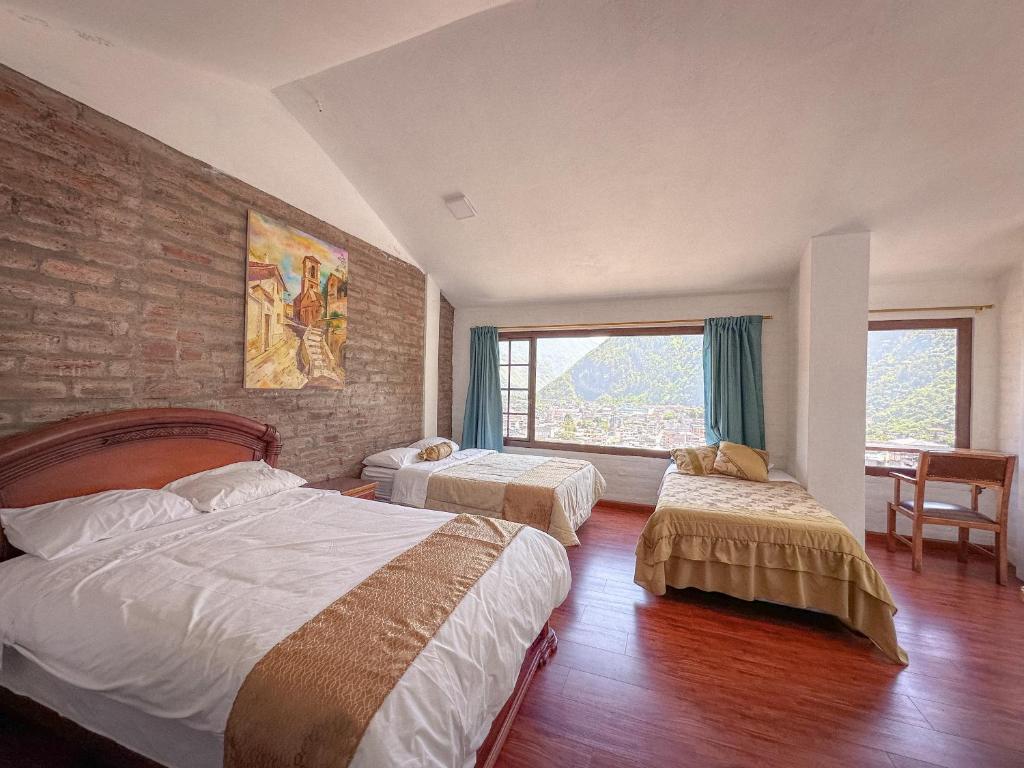 a bedroom with two beds and a brick wall at Mercedes Restaurant B&B in Baños