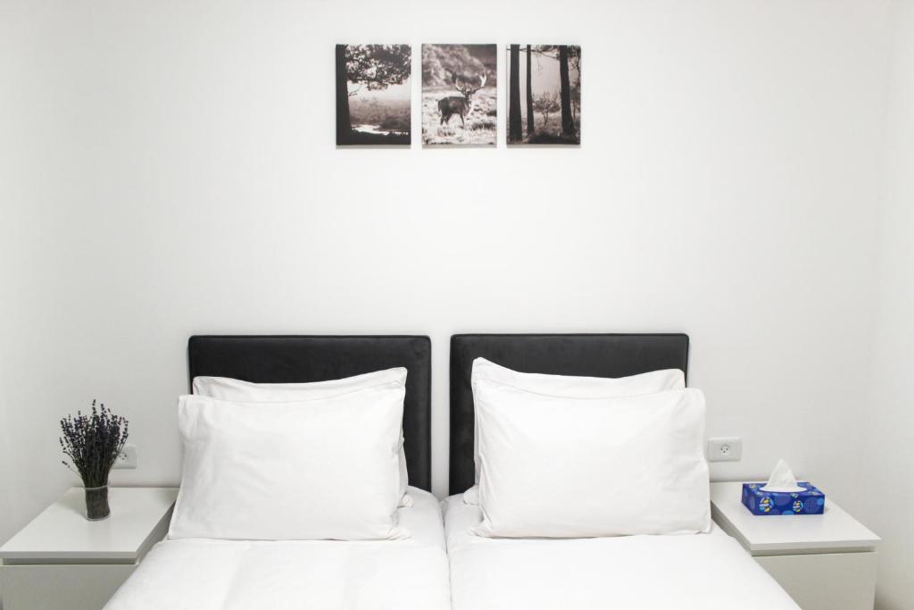 a bed with two white pillows and two pictures on the wall at Luxury Family Apartment #30 By Hashdera Eilat in Eilat