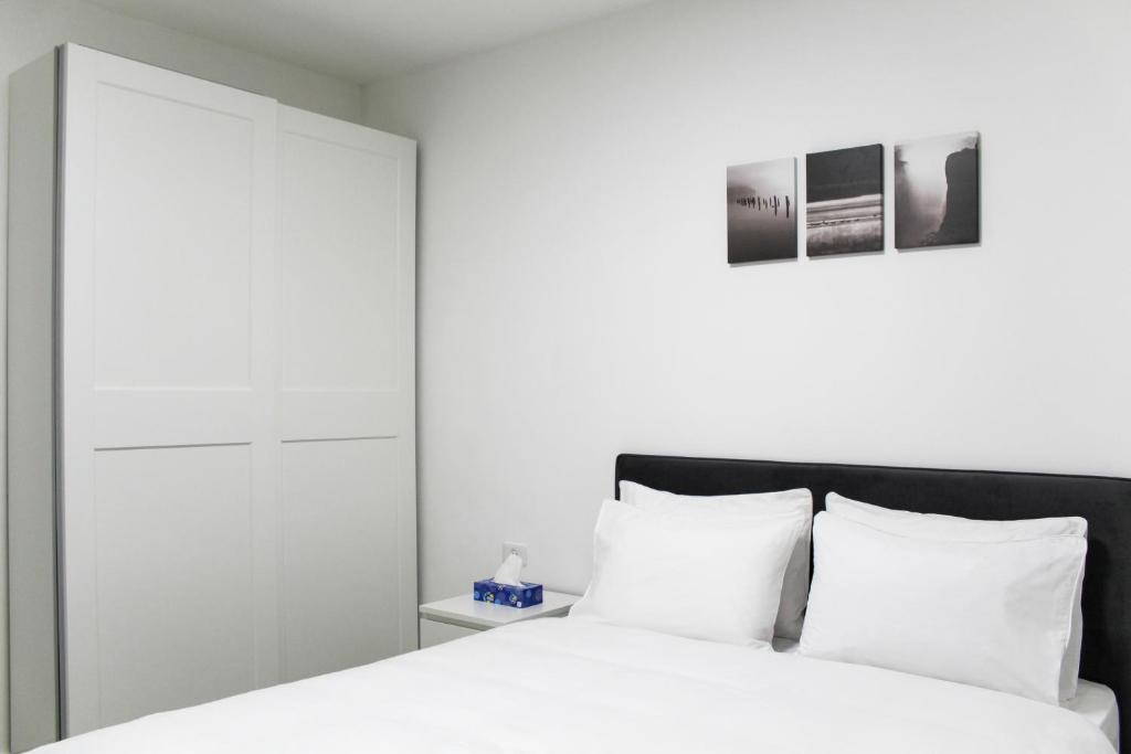 a bedroom with a white bed with white pillows at Luxury Family Apartment #30 By Hashdera Eilat in Eilat