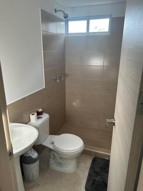 a bathroom with a toilet and a sink at Departamento nuevo de estreno in Candelaria