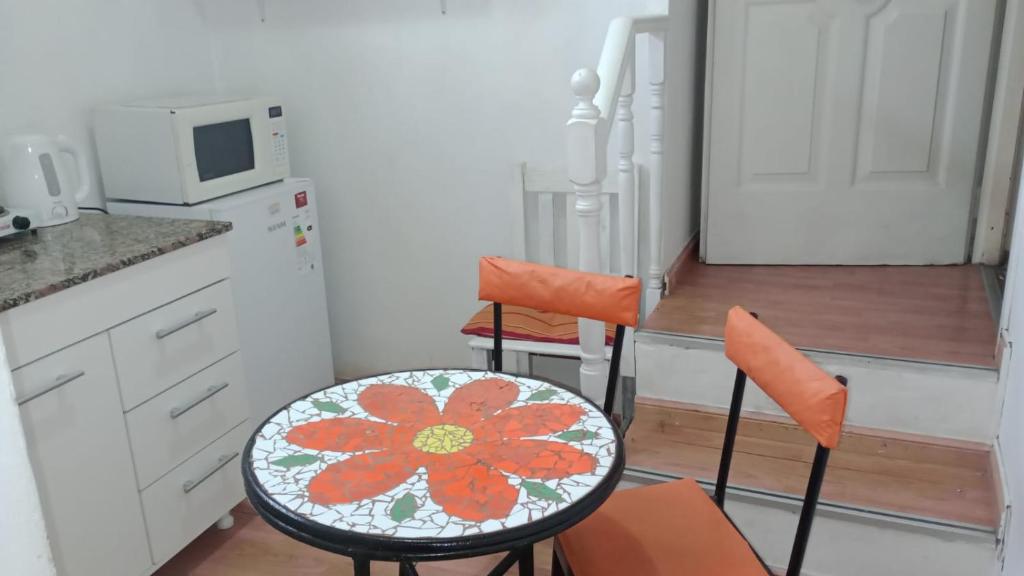 a kitchen with two chairs and a table with a flower on it at Luminoso Depto S Fernando a 100 m Estación in San Fernando