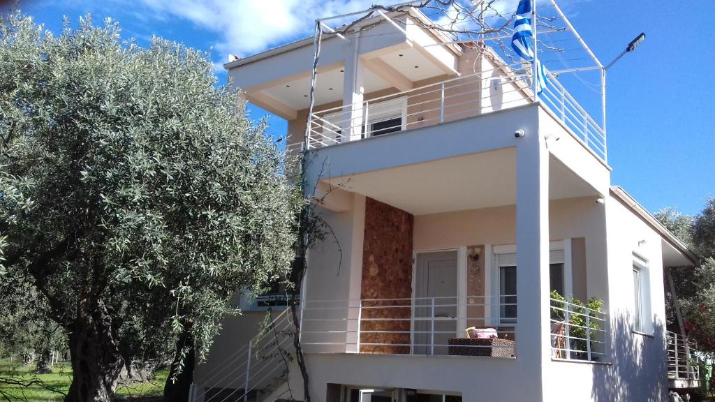 a white house with a tree in front of it at SUN GARDEN in Skala Sotiros