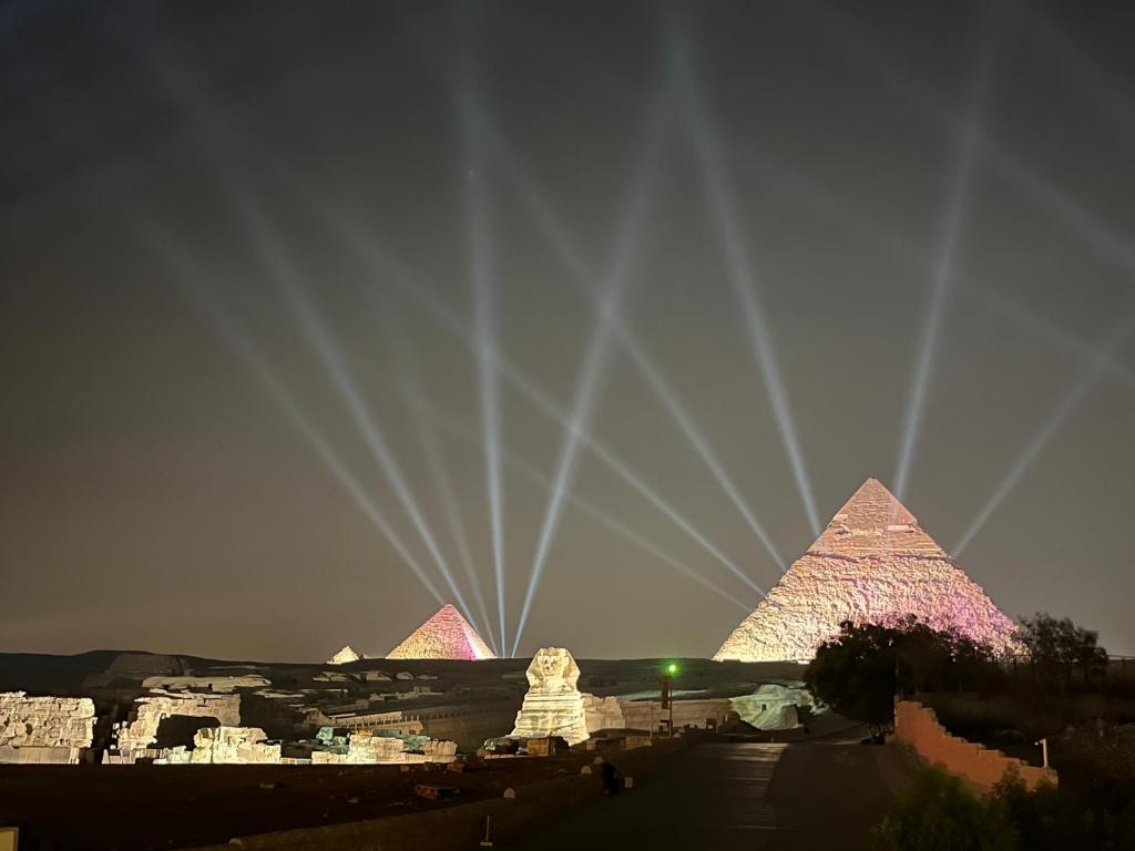 a view of the pyramids of giza at night at The Gate Hotel Pyramids in Cairo