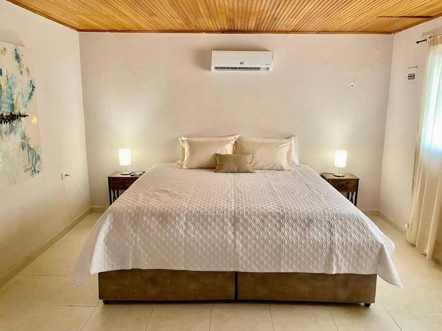 Apto Valle Suites, La Mejor Zona في فاليدوبار: غرفة نوم بسرير كبير مع مواقف ليلتين