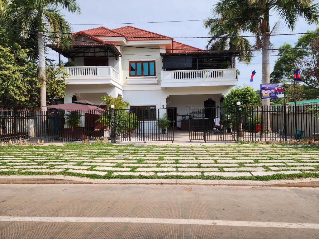 una casa bianca con una recinzione di fronte a un cortile di Youth's Dream Fulfillment Association a Siem Reap