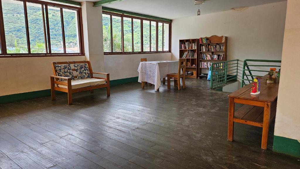 Cette chambre comprend une table, des chaises et des fenêtres. dans l'établissement Casa Verde, à Quillabamba