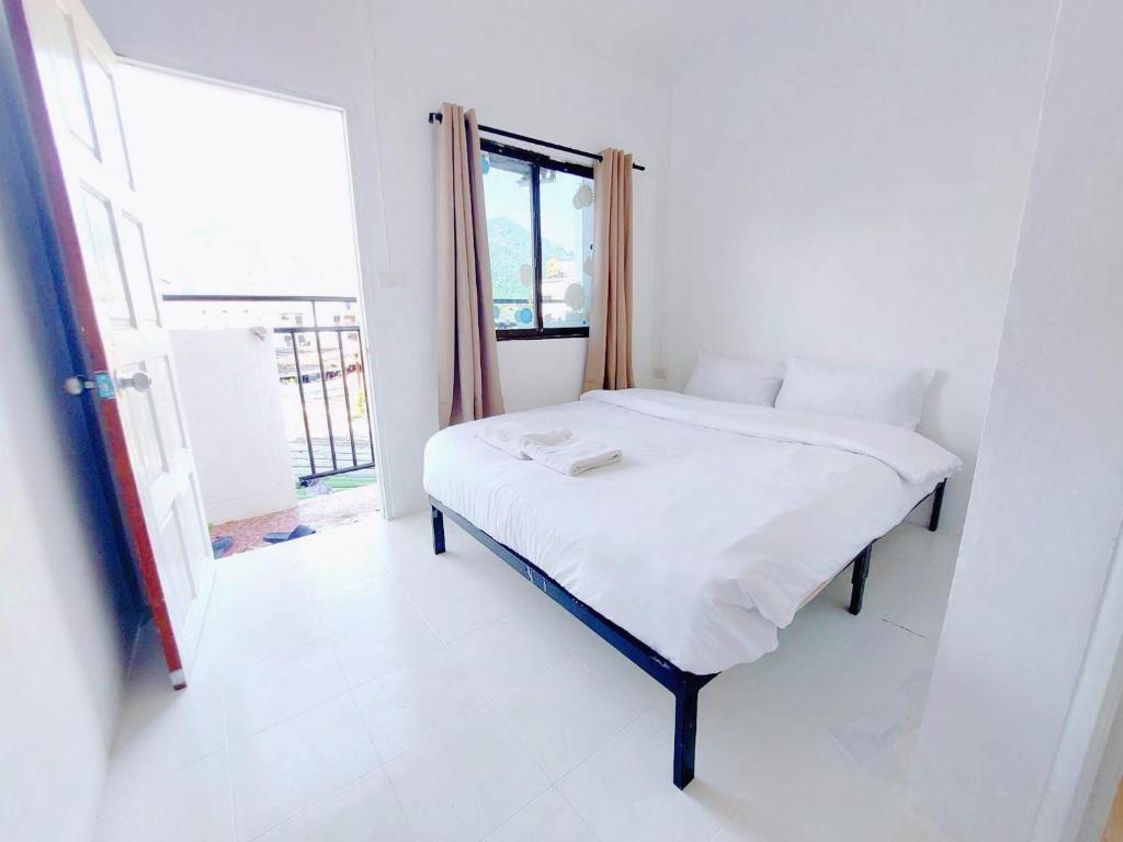 a white bed in a room with a window at เบา ป่าตอง Bao Pathong Beach in Patong Beach