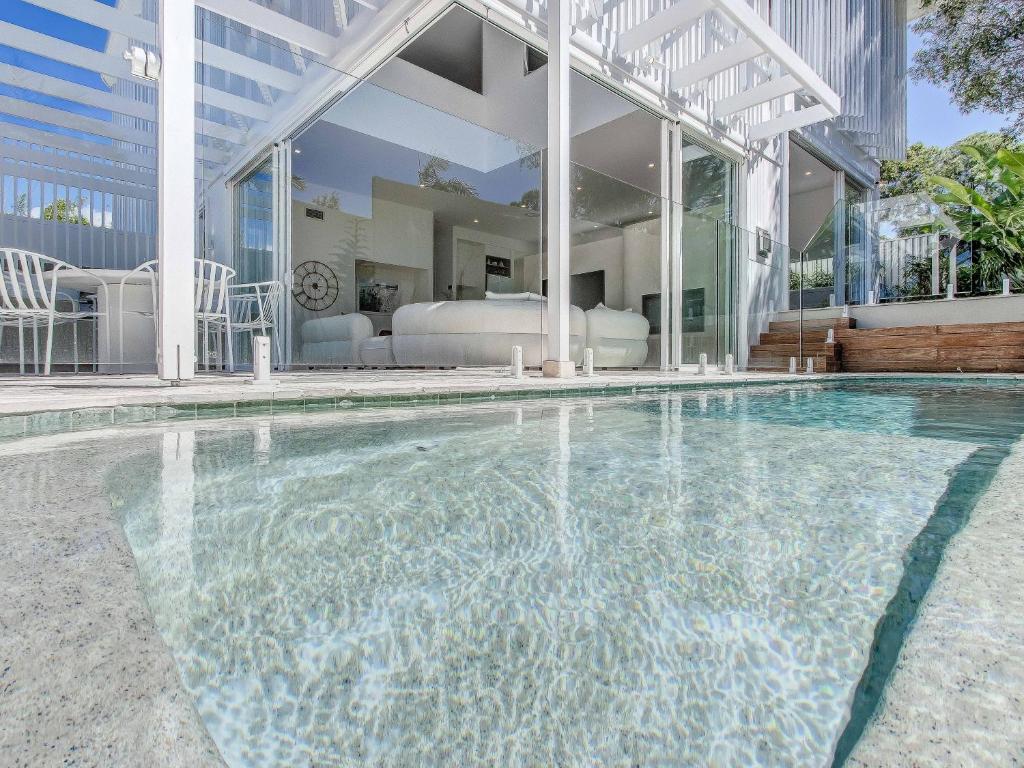 a swimming pool in front of a house at Luxury Mermaid Waters Holiday Home in Gold Coast