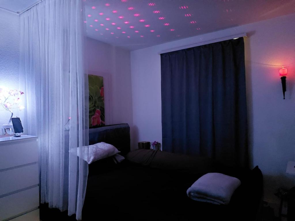 Habitación con sofá y ventana con luces moradas. en Mystay42 en Luzern