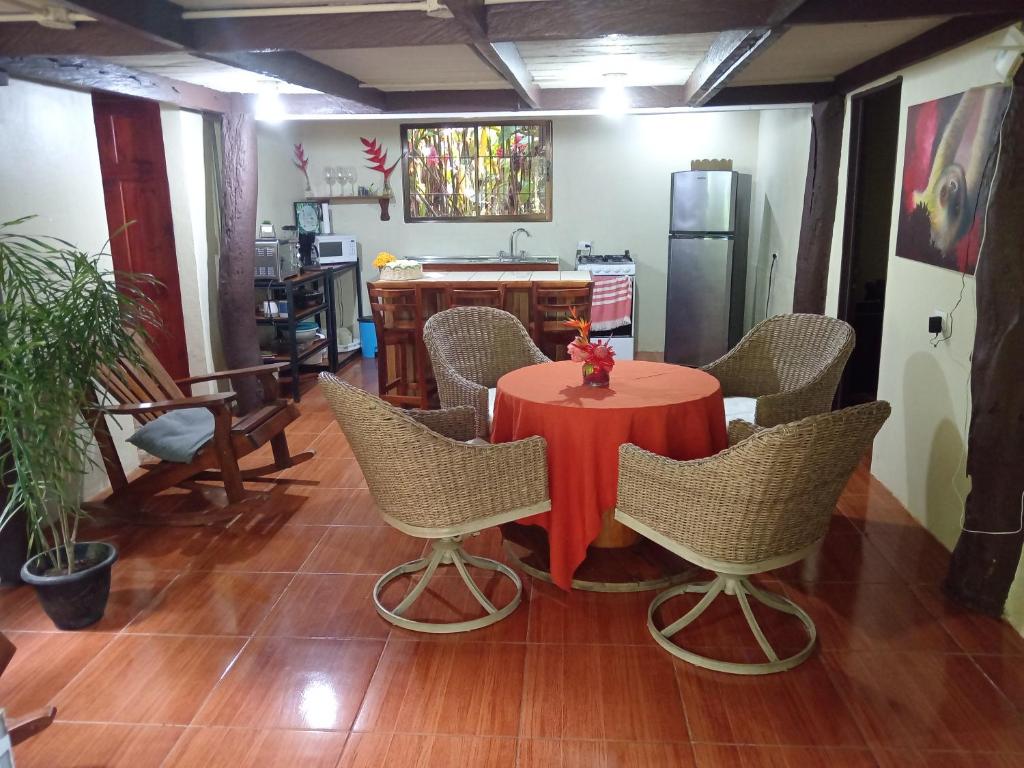 a dining room with a red table and chairs at Finca La Paz in Puerto Viejo