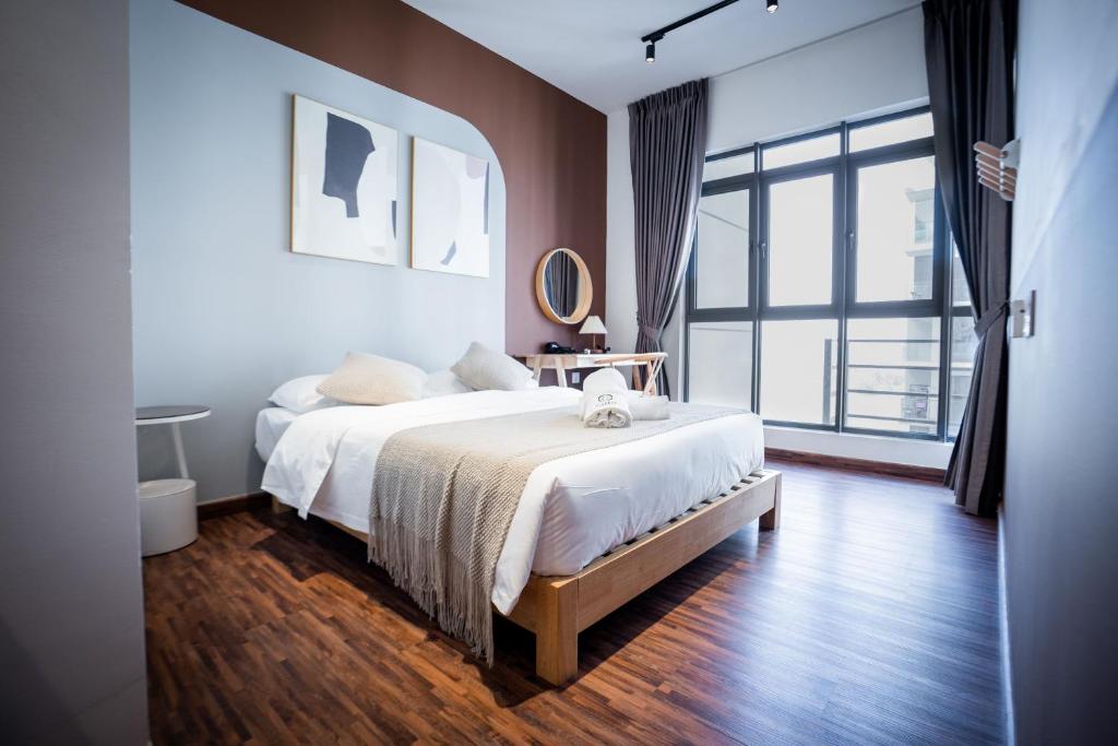 een slaapkamer met een bed en een groot raam bij K Avenue by Pinstay in Donggongon