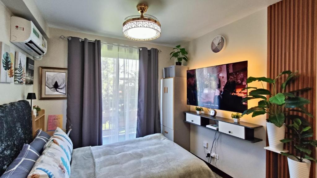 a living room with a couch and a flat screen tv at SAEKYUNG CoNDo HoMESTaY in Lapu Lapu City