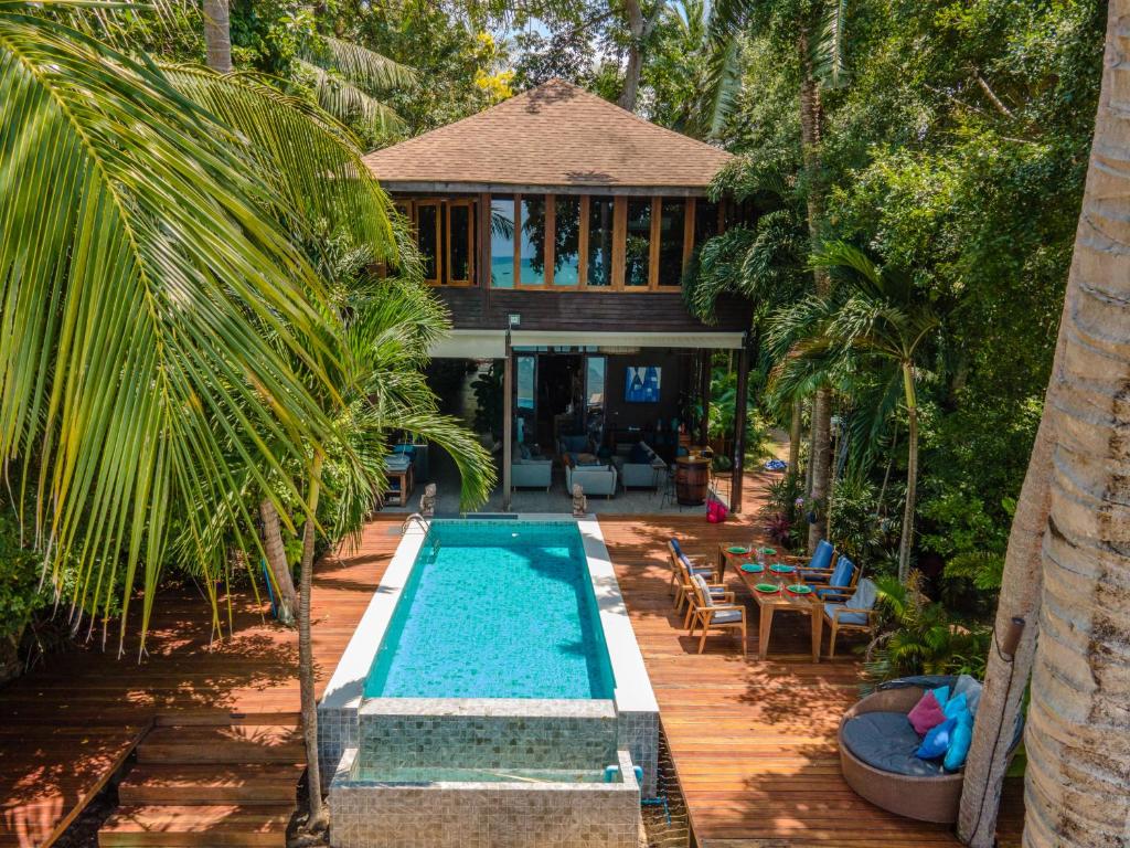 a swimming pool in front of a house at Private Beach House @ Hin Kong Beach in Hinkong