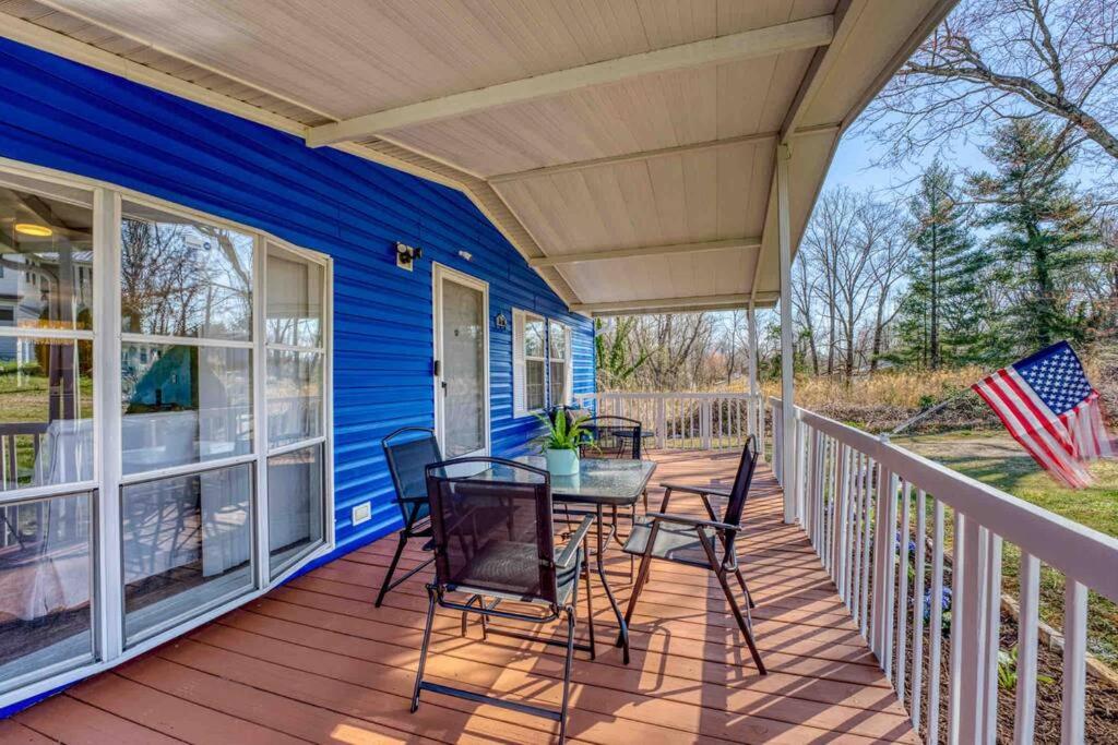 un porche de una casa azul con mesa y sillas en Blue Ridge Haven: Close to Everything!, en Asheville