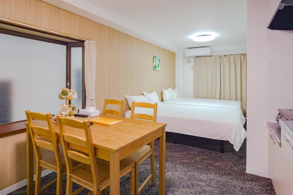 a hotel room with a bed and a table and chairs at Tutulu201 in Osaka