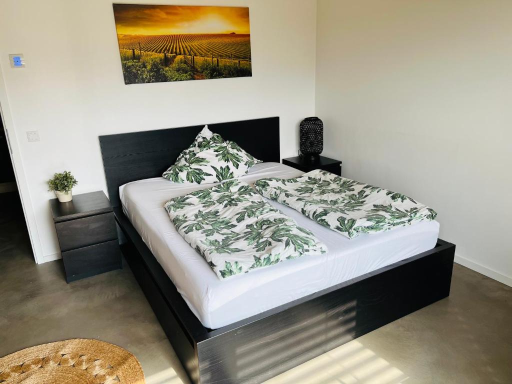 a bedroom with a bed with a black and white comforter at Modernes Apartment am Waldrand in Geisenheim