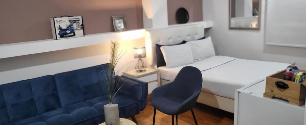 a bedroom with a bed and a blue chair at Glow Boutique Hotel Zona G in Bogotá