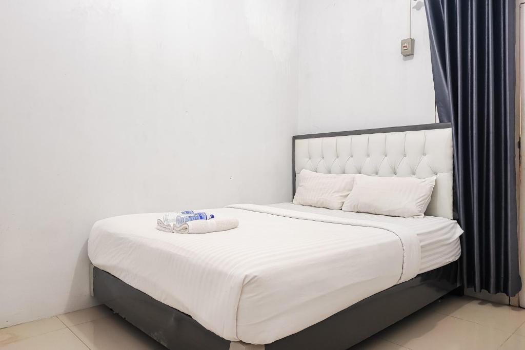 a white bed with a bowl on top of it at RedDoorz Syariah near Lapangan Persijam Jambi in Paalmerah