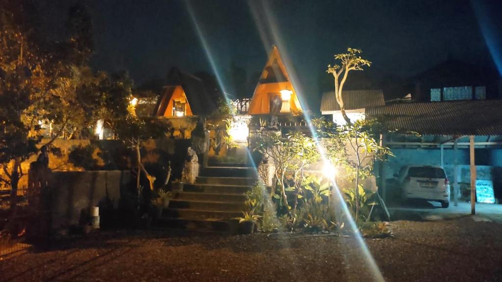 una casa con escaleras delante de ella por la noche en Candra Homestay Besakih, en Besakih