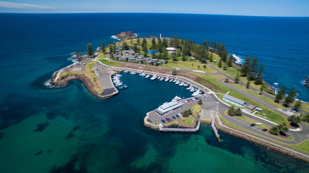 an island with a marina with boats in the water at Kiama Harbour Cabins in Kiama