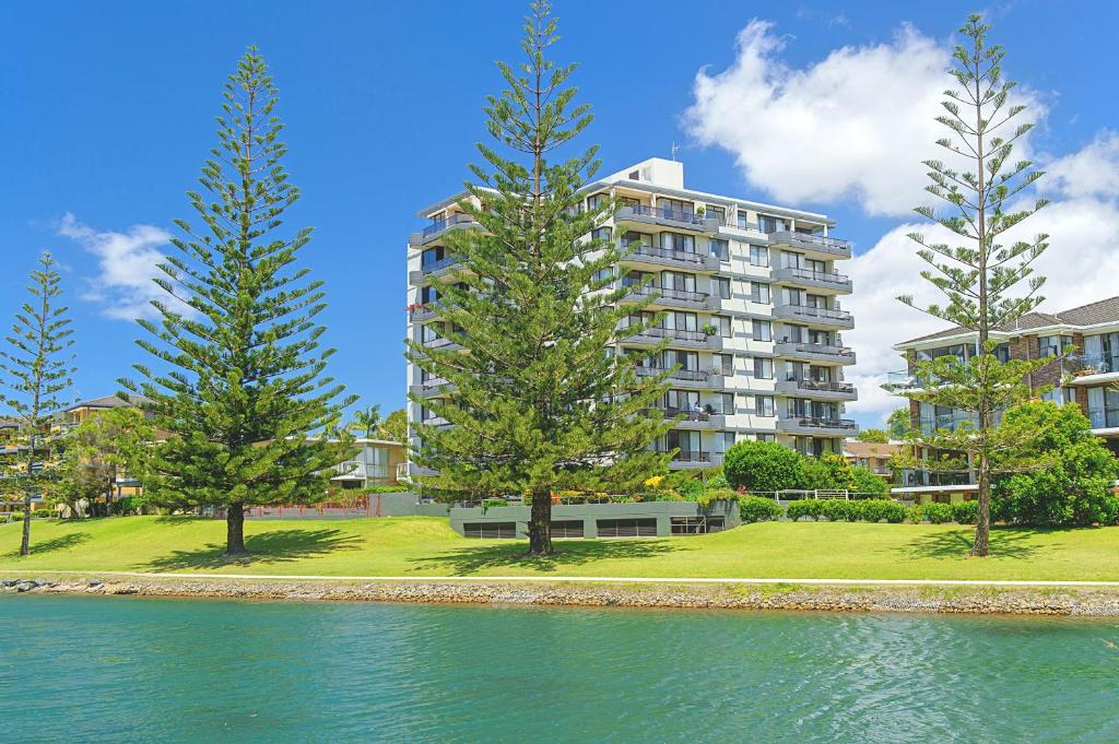 a large apartment building with trees in front of the water at Sundial 202 8-10 Hollingworth Street in Port Macquarie