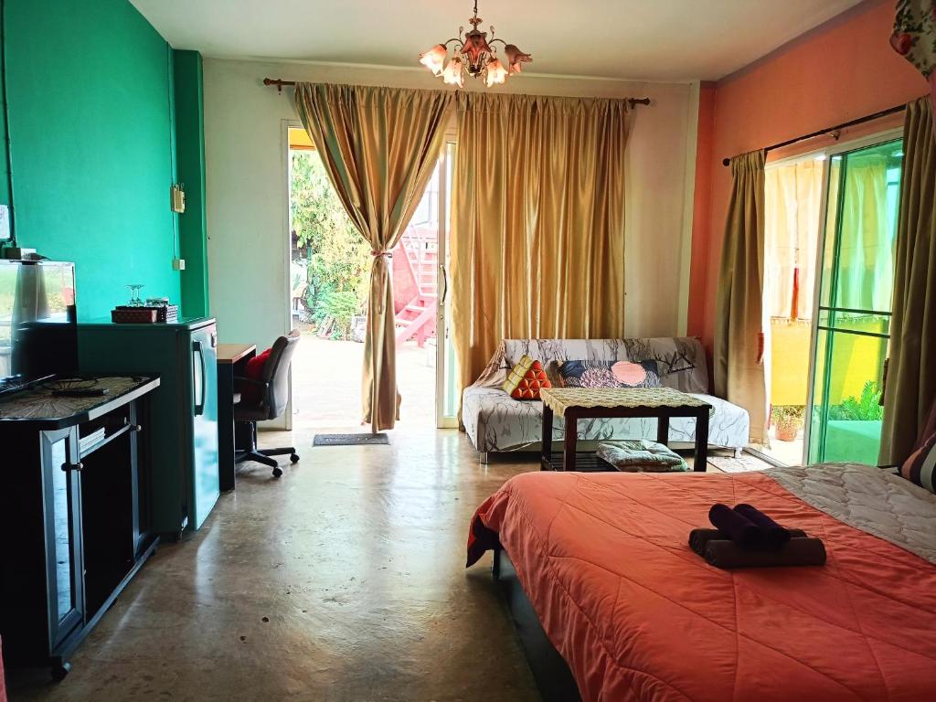- une chambre avec un lit et un canapé dans l'établissement Six Nature Resort, à Chiang Rai