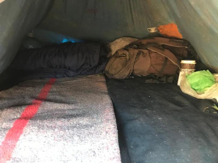 a bed in a tent with a pile of bags at Pedro's camp in Agadir