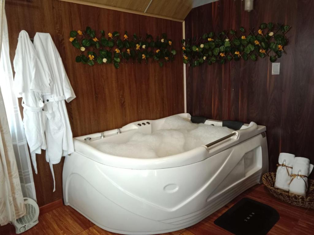 a white bath tub in a bathroom with wooden walls at El Encanto de Tota los Pensamientos in Tota