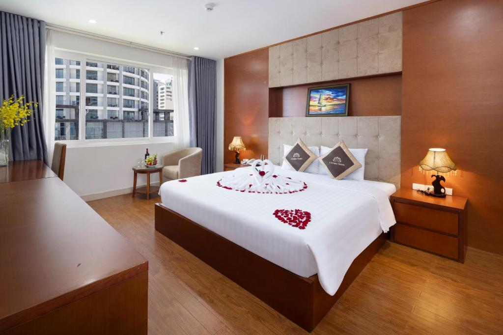 a bedroom with a large white bed with a red heart on it at T78 Nha Trang Hotel in Nha Trang