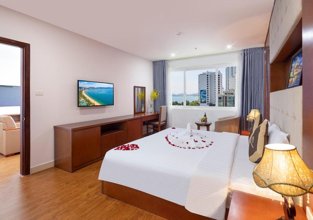 ein Hotelzimmer mit einem Bett und einem TV in der Unterkunft T78 Nha Trang Hotel in Nha Trang